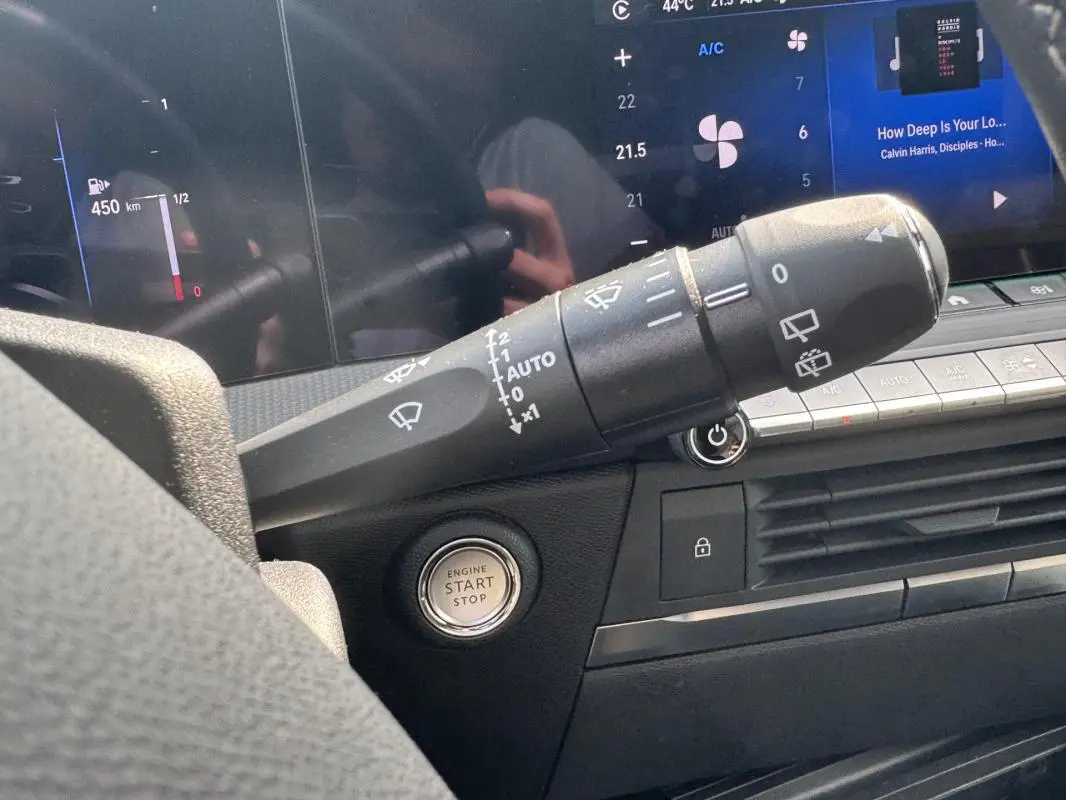 Gros plan intérieur sur la commande d’essuie-glace et bouton start/stop de l’Opel Astra gris 2024, tableau de bord numérique.