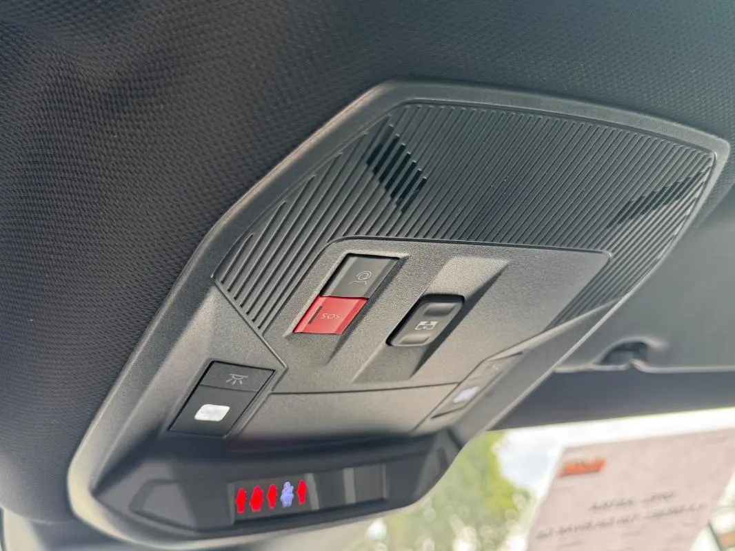 Vue en gros plan du plafonnier gris de l’Opel Astra 2024 avec boutons SOS et éclairage intégré.