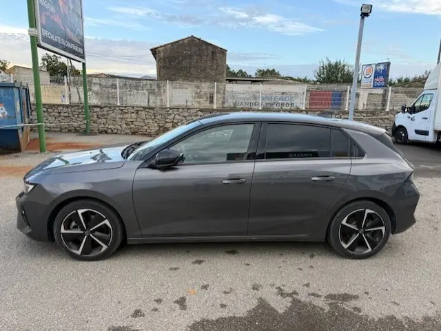 Vue de profil côté gauche d'une Opel Astra gris métallisé 2024, version 1.5 Diesel 130 ch avec jantes alliage distinctives.