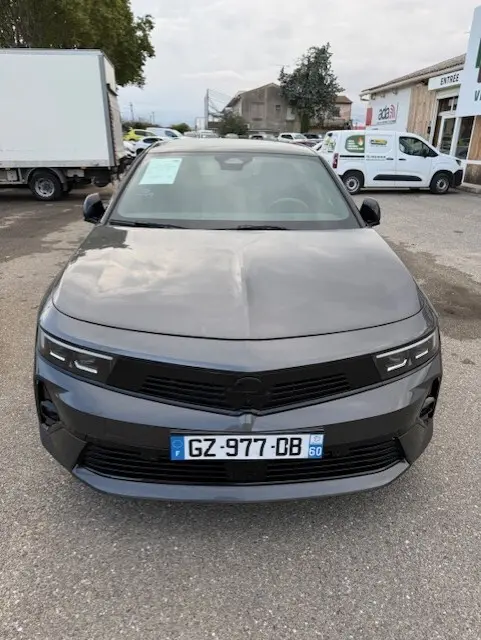 Vue avant d'une Opel Astra gris métallisé 2024 avec calandre noire et plaques d'immatriculation françaises.