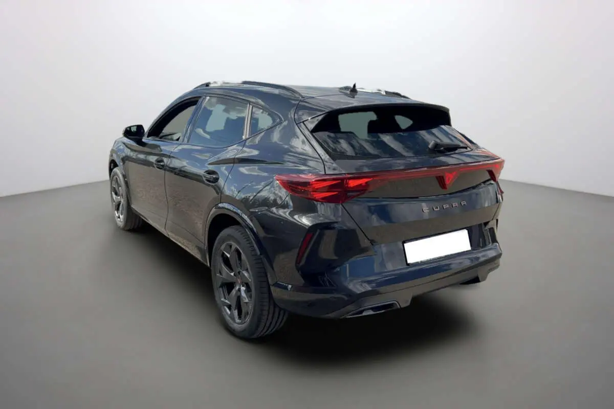 Vue 3/4 arrière d'une CUPRA Formentor noir minuit avec jantes alu 18 pouces et feux arrière full LED.