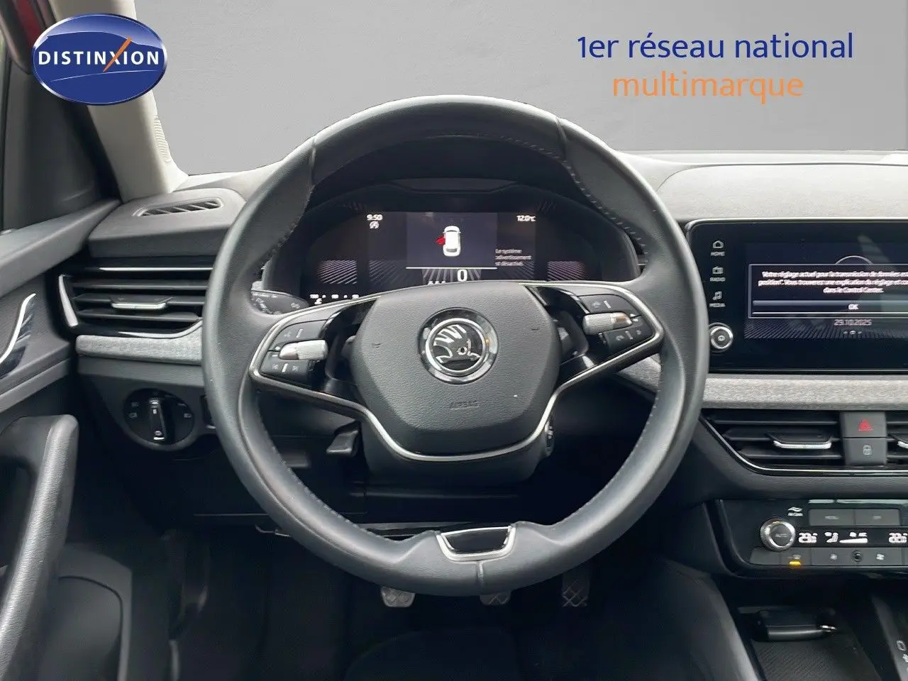 Vue centrée du volant et tableau de bord d'une Skoda Kamiq 2024, intérieur noir avec écran tactile et commandes au volant.