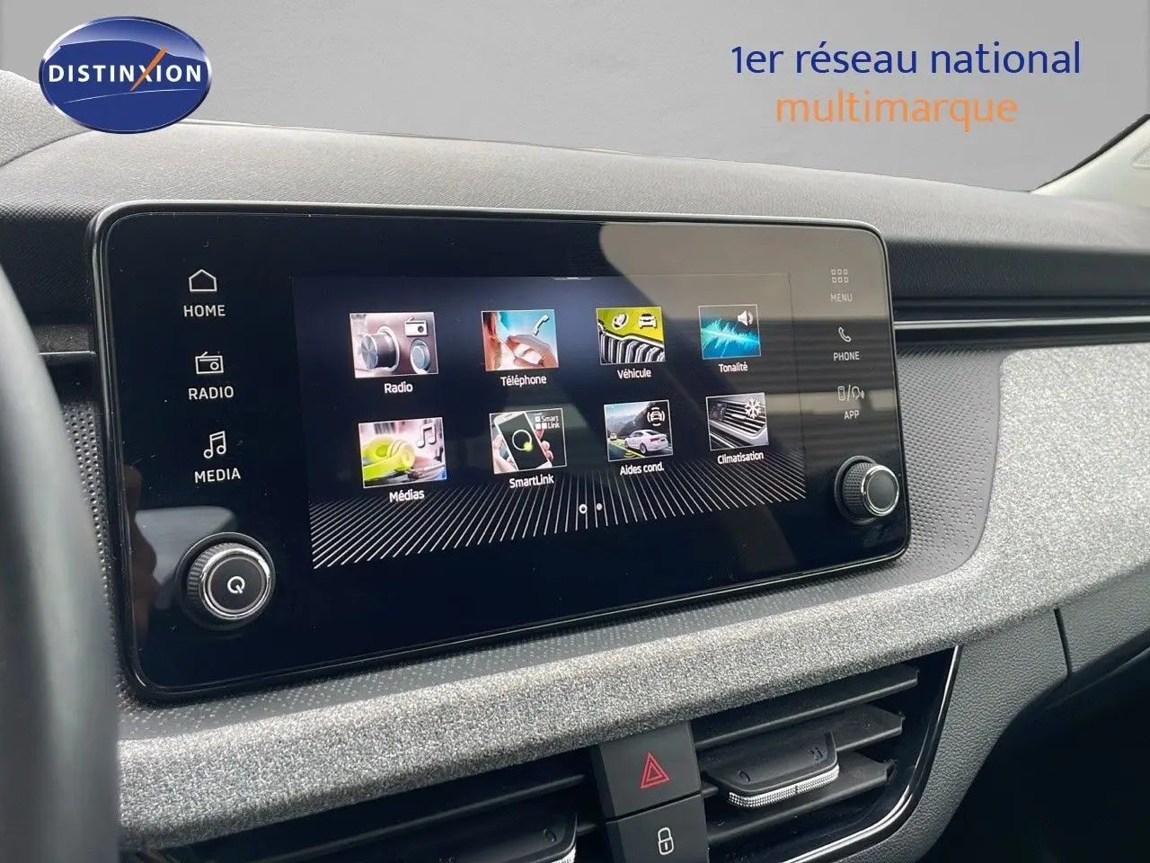 Tableau de bord du Skoda Kamiq 2024 avec écran tactile central et finition tissu gris noir, vue intérieure frontale.