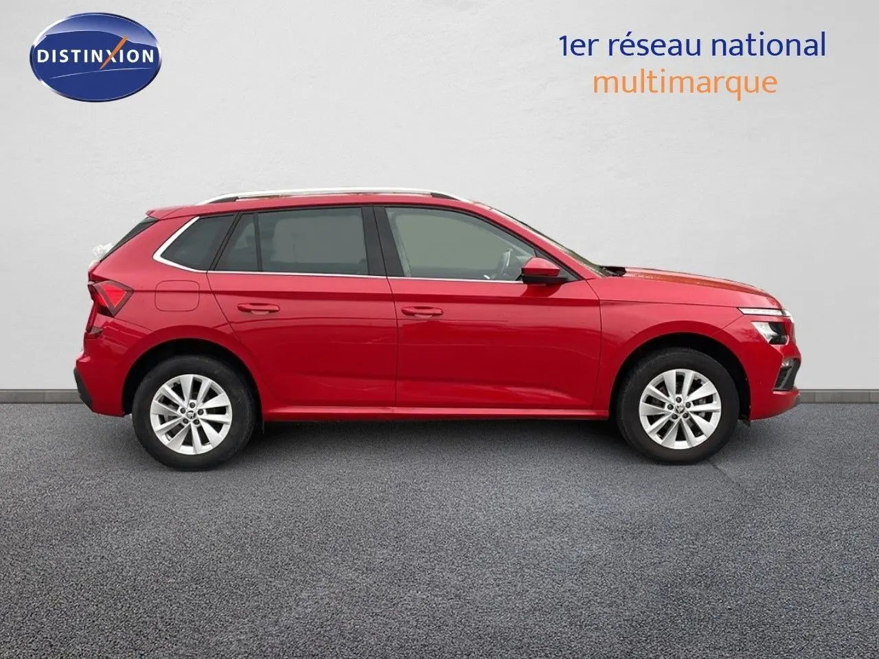 Vue de profil côté gauche d'un Skoda Kamiq 2024 rouge Velvet Metal avec jantes alliage et toit ouvrant.