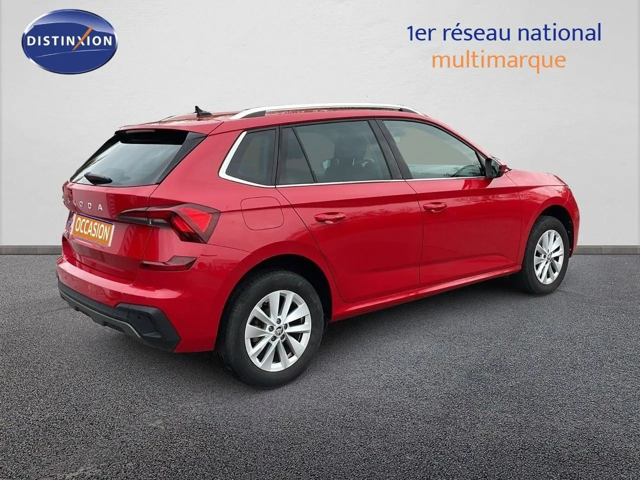 Vue 3/4 arrière droite d'un Skoda Kamiq rouge Velvet Metal avec jantes alliage et toit ouvrant.