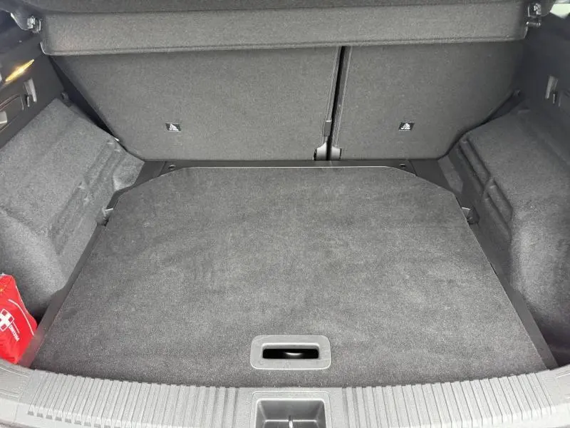 Coffre ouvert vu de face du Renault Austral 2024, intérieur noir avec tapis de sol et rangement plat.