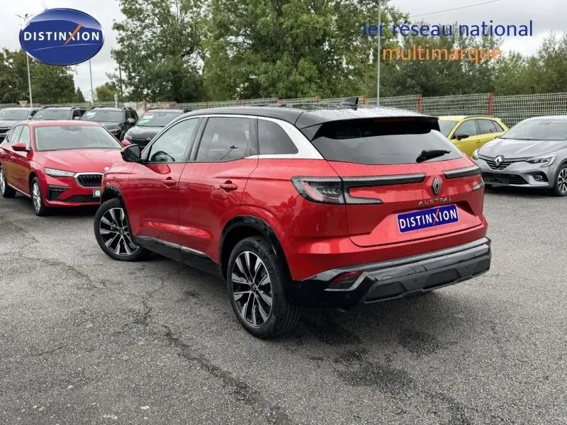 Vue 3/4 arrière droite du Renault Austral rouge Flamme avec toit noir étoilé et jantes alu noires et argentées.