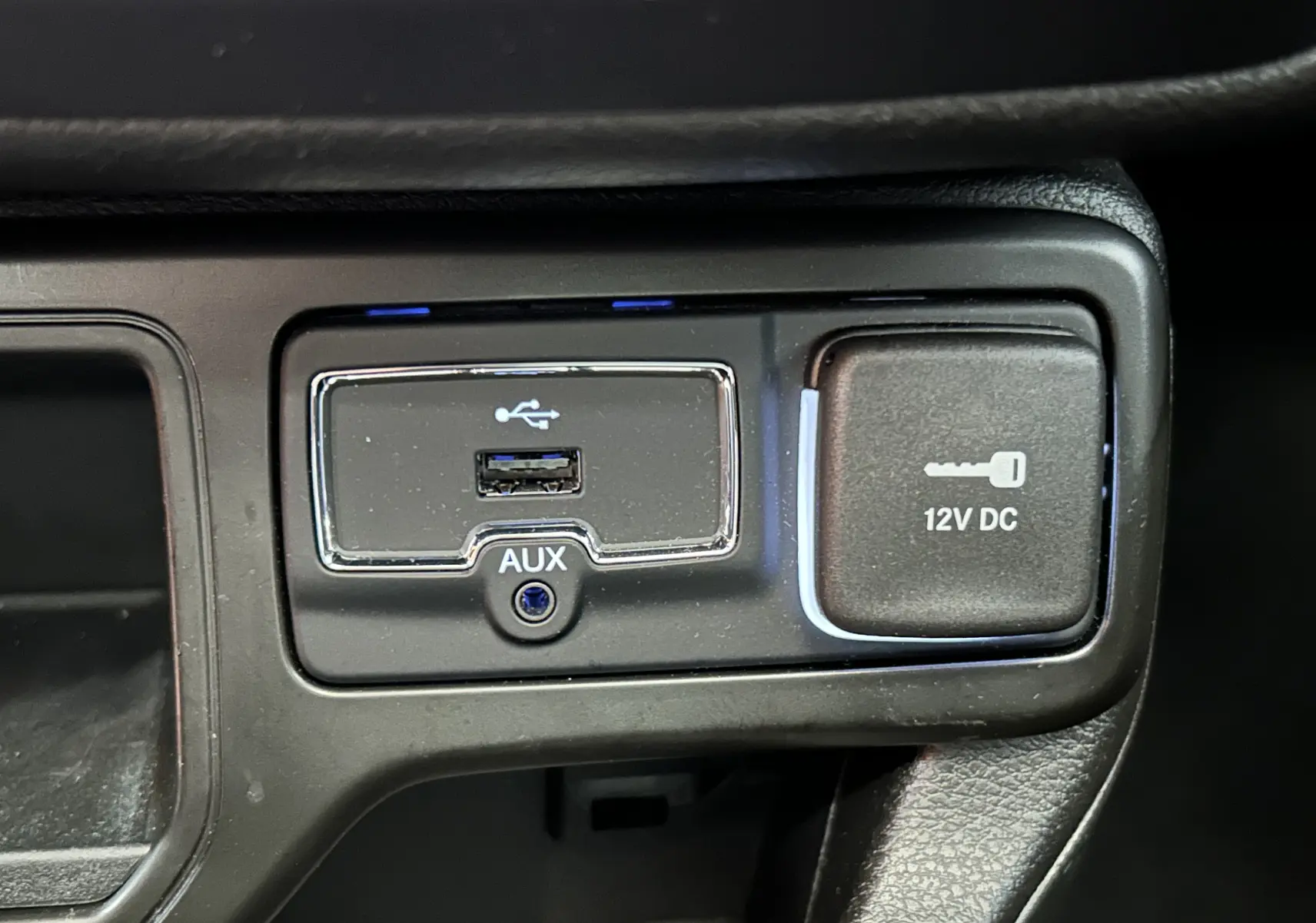 Gros plan sur la prise USB, port AUX et prise 12V DC du tableau de bord du Jeep Renegade gris graphite 2023.