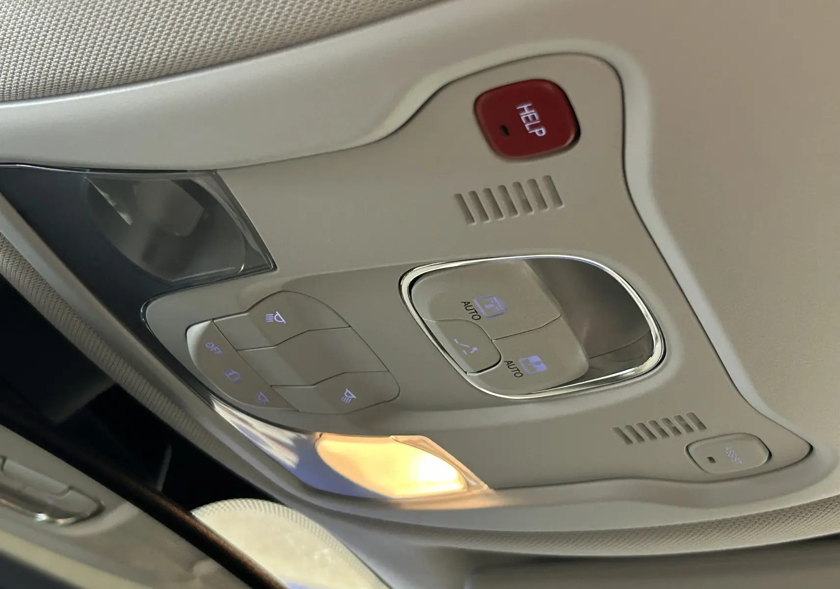Plafonnier intérieur beige avec commandes d'éclairage et bouton d'assistance rouge dans une Jeep Renegade 2023.