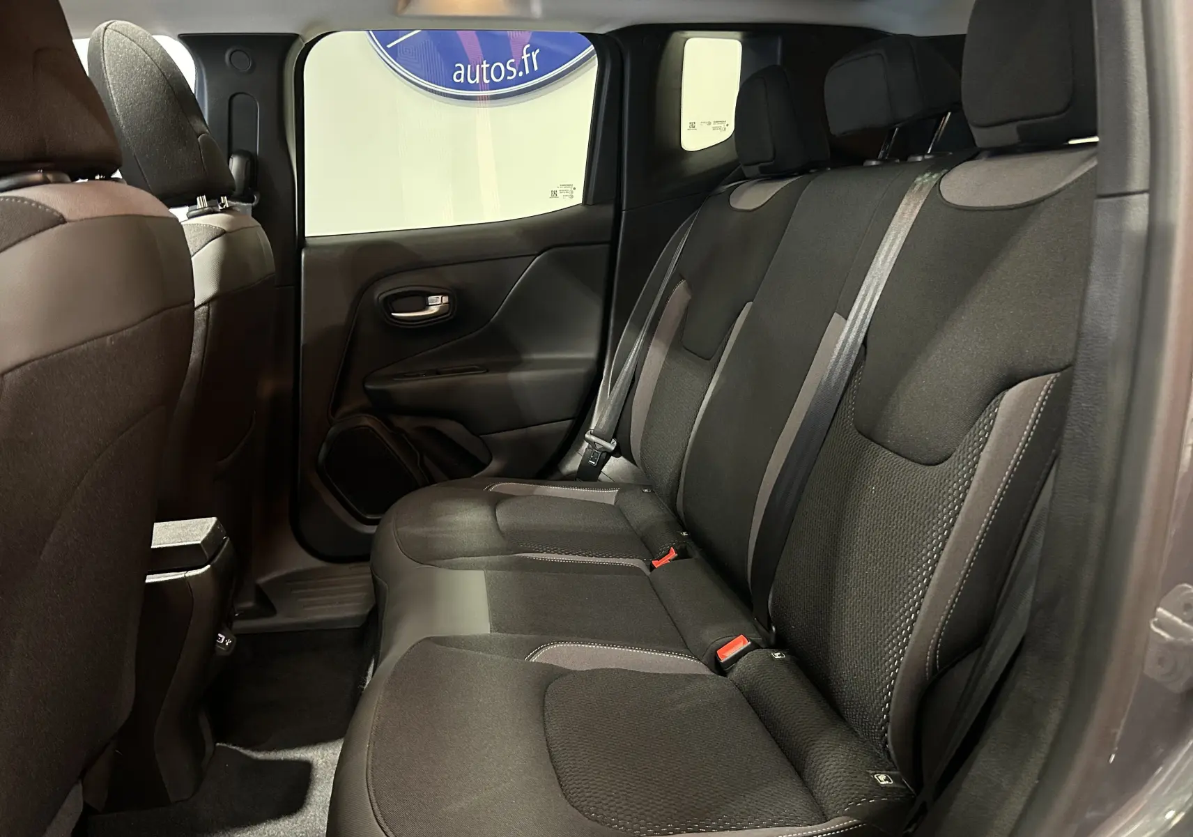 Vue intérieure côté droit des sièges arrière noirs du Jeep Renegade gris graphite, mettant en valeur l'espace et la finition tissu.