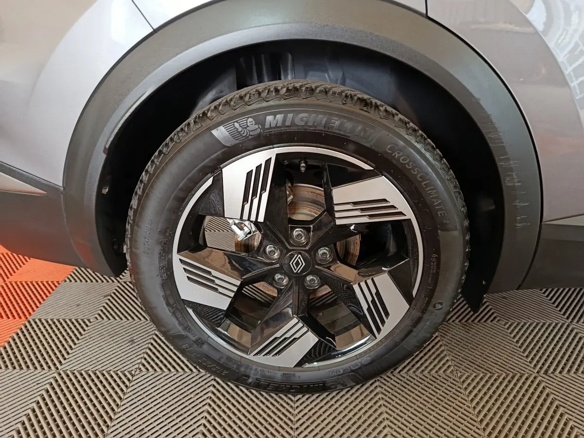 Gros plan sur la roue avant droite argentée du Renault Symbioz avec jante noire et argentée au design moderne.