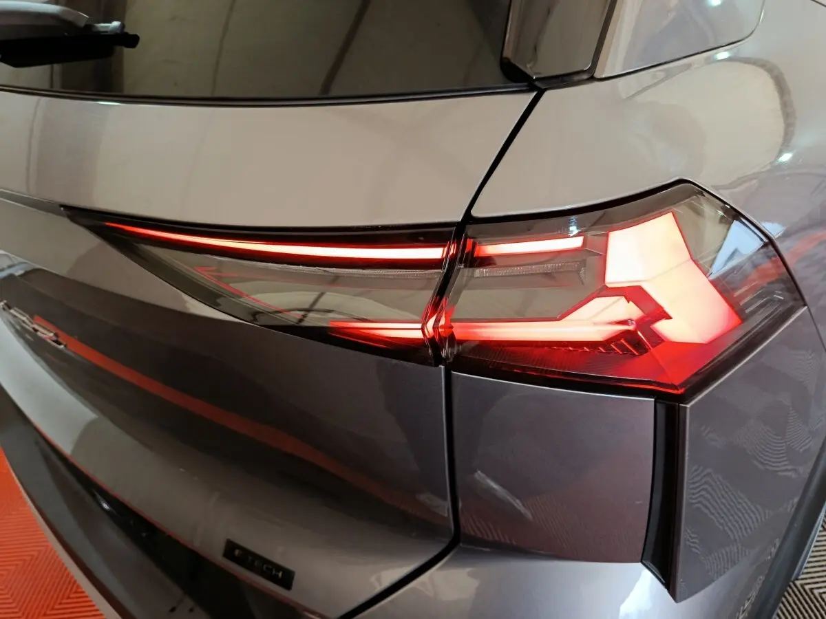 Gros plan sur le feu arrière droit rouge et blanc du Renault SYMBIOZ gris, version iconic E-Tech full hybrid 145.