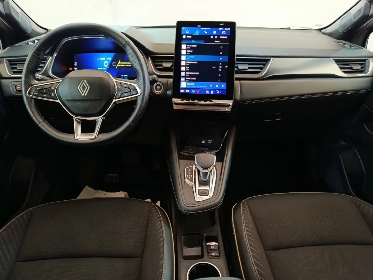 Intérieur noir du Renault SYMBIOZ 2025, vue de face sur le volant, écran tactile vertical et console centrale.