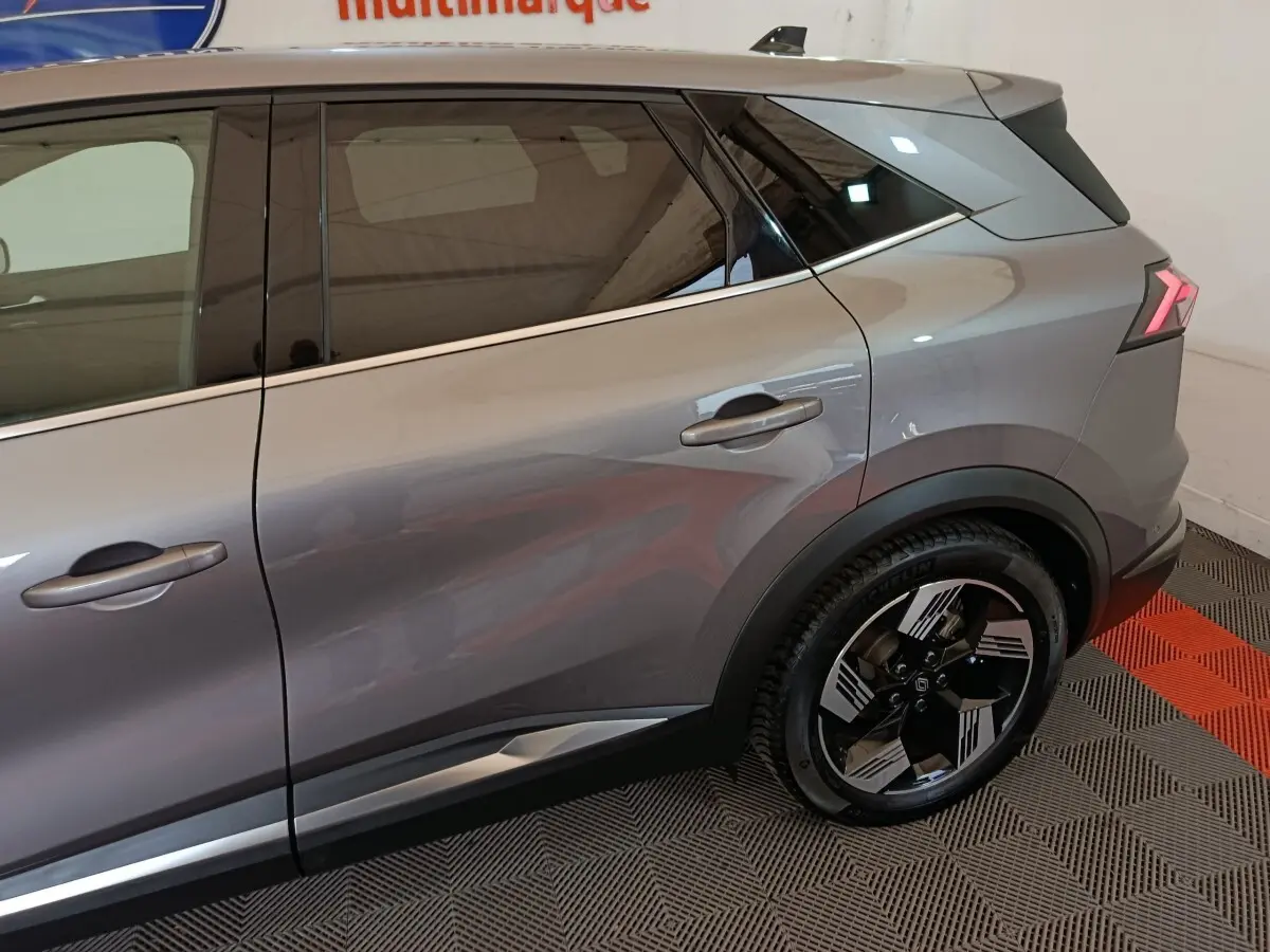 Vue latérale droite du Renault SYMBIOZ gris métallisé, mettant en valeur la porte arrière et la roue au design moderne.