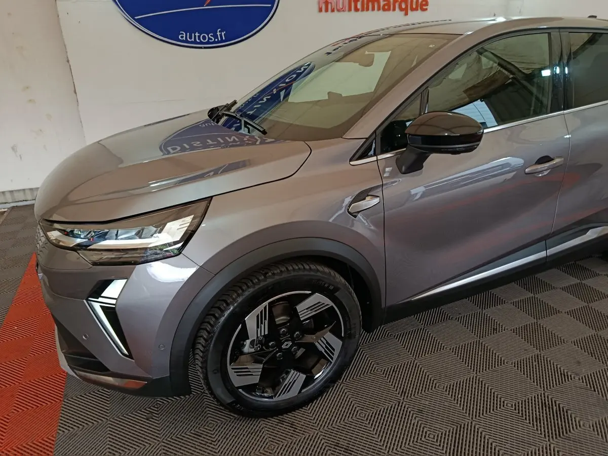 Vue 3/4 avant droit d'une Renault SYMBIOZ gris métallisé avec phares LED et jantes noires au design futuriste.