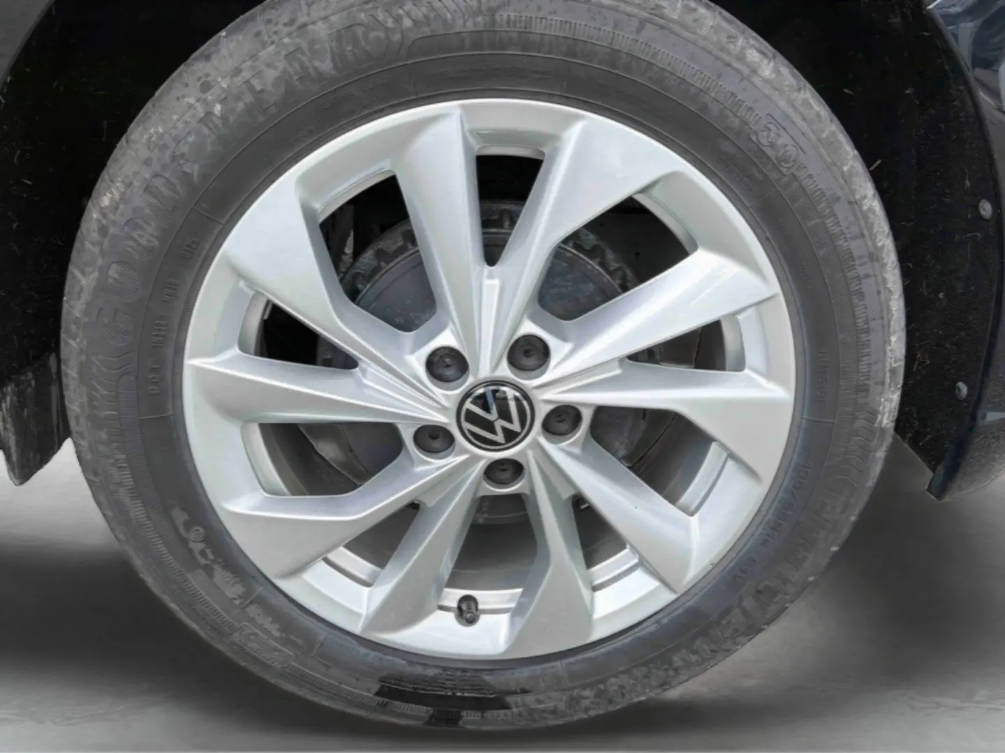 Gros plan sur la jante alliage 16'' Palermo argentée d'une Volkswagen Polo noire, avec logo VW central visible.