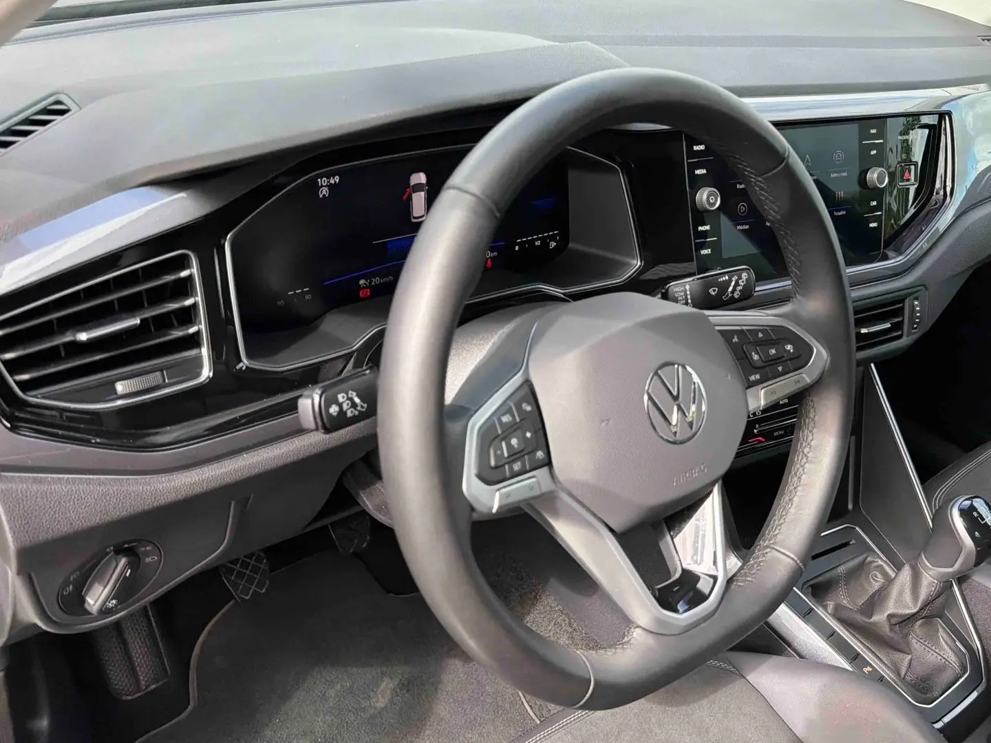 Vue intérieure rapprochée du volant cuir multifonctions et du tableau de bord digital de la Volkswagen Polo noire 2025.