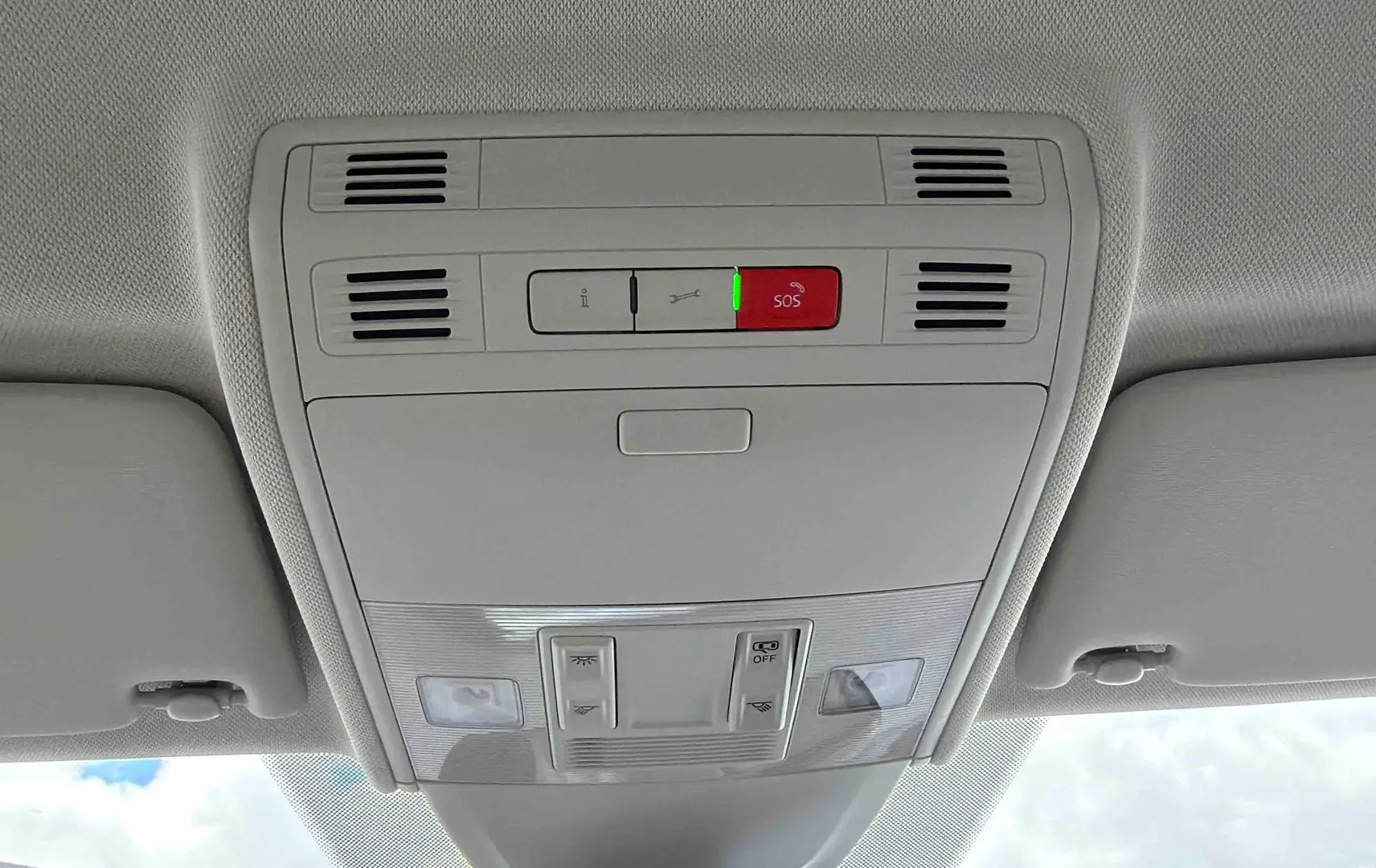 Vue intérieure du plafonnier gris clair avec boutons de commande et alerte SOS allumée dans une Volkswagen Polo noire.