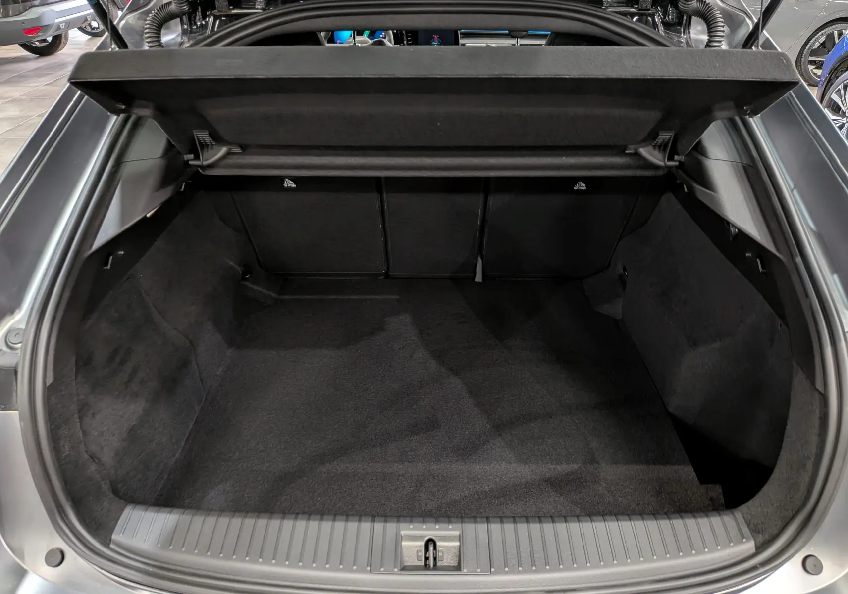 Coffre ouvert vu de l'arrière d'une Renault Rafale gris schiste satin, espace de chargement vide et propre.