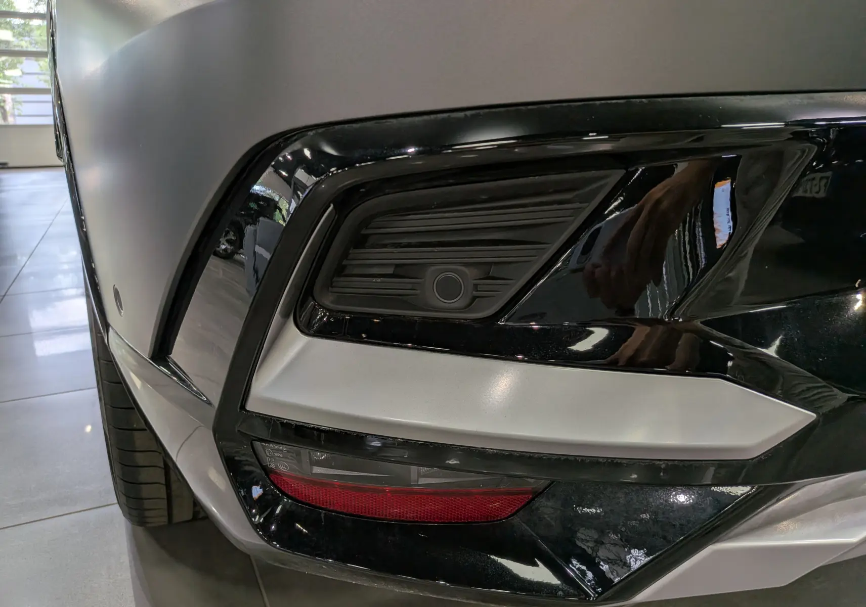 Gros plan sur le pare-chocs arrière droit gris Schiste Satin du Renault Rafale avec détails noirs et feu rouge intégré.