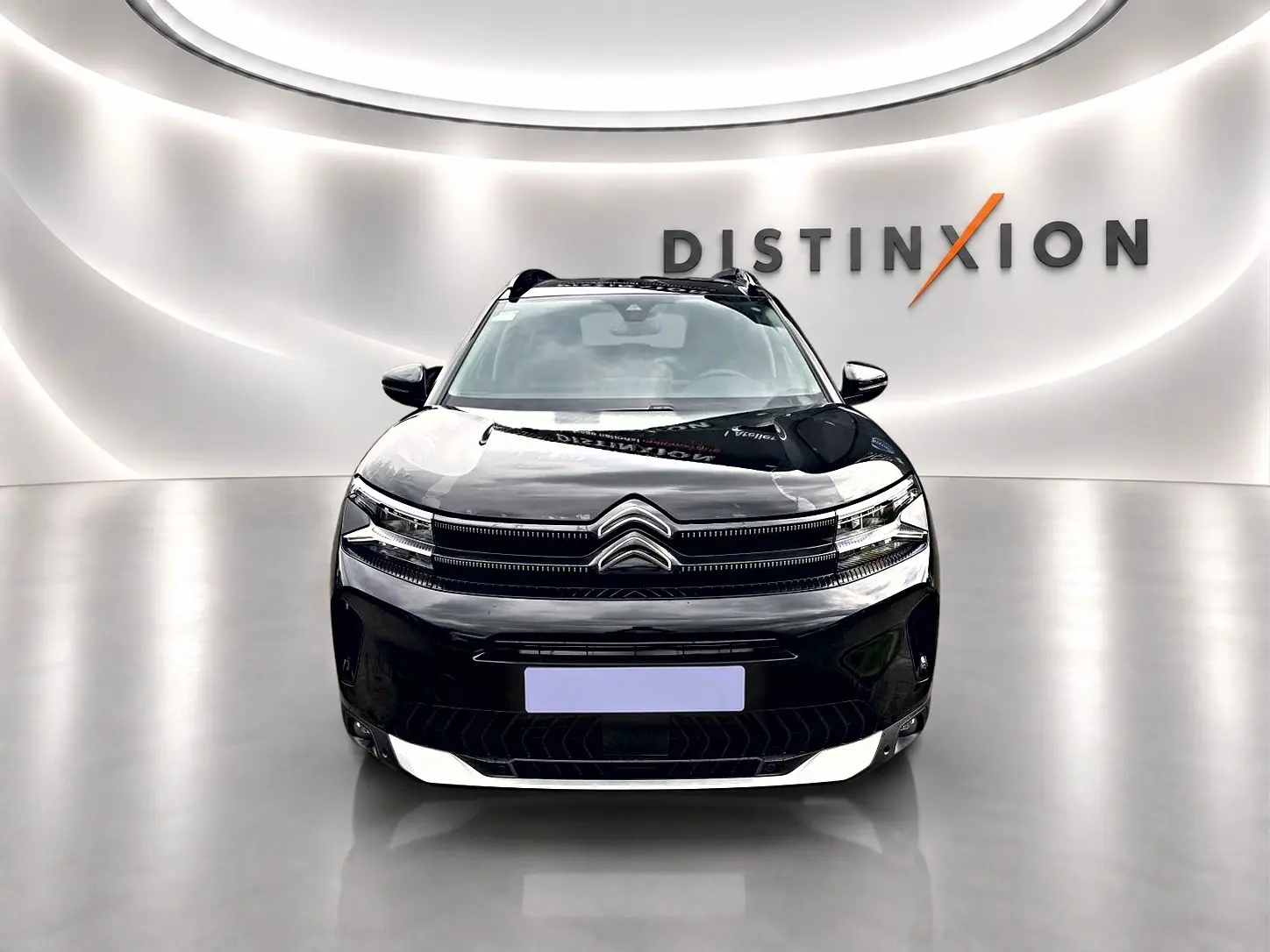 Citroën C5 Aircross noir vue de face dans un showroom avec éclairage moderne et logo Distinxion en arrière-plan.