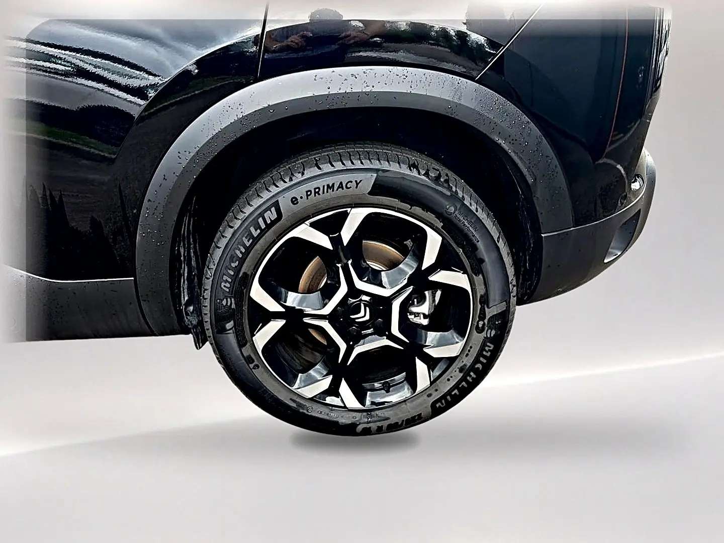 Gros plan sur la roue arrière droite noire du Citroën C5 Aircross 2025 avec jante alu bicolore et pneus Michelin.