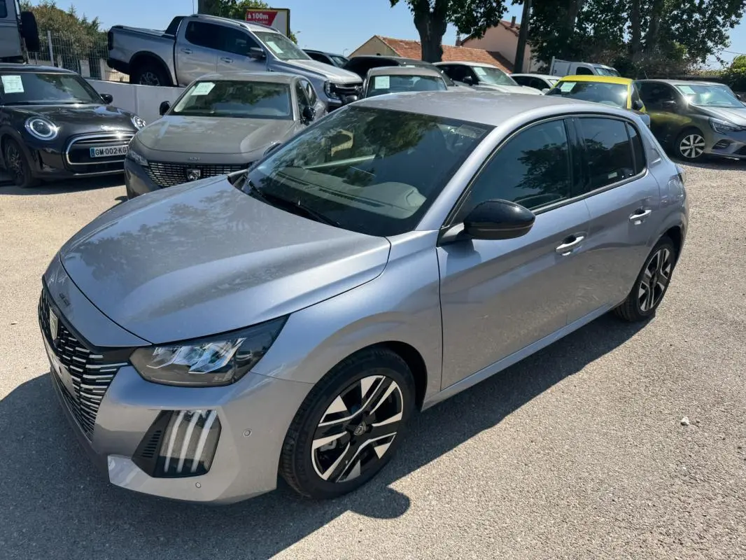 Peugeot 208 Hybrid gris vue 3/4 avant droit, avec jantes alliage noires et calandre distinctive.