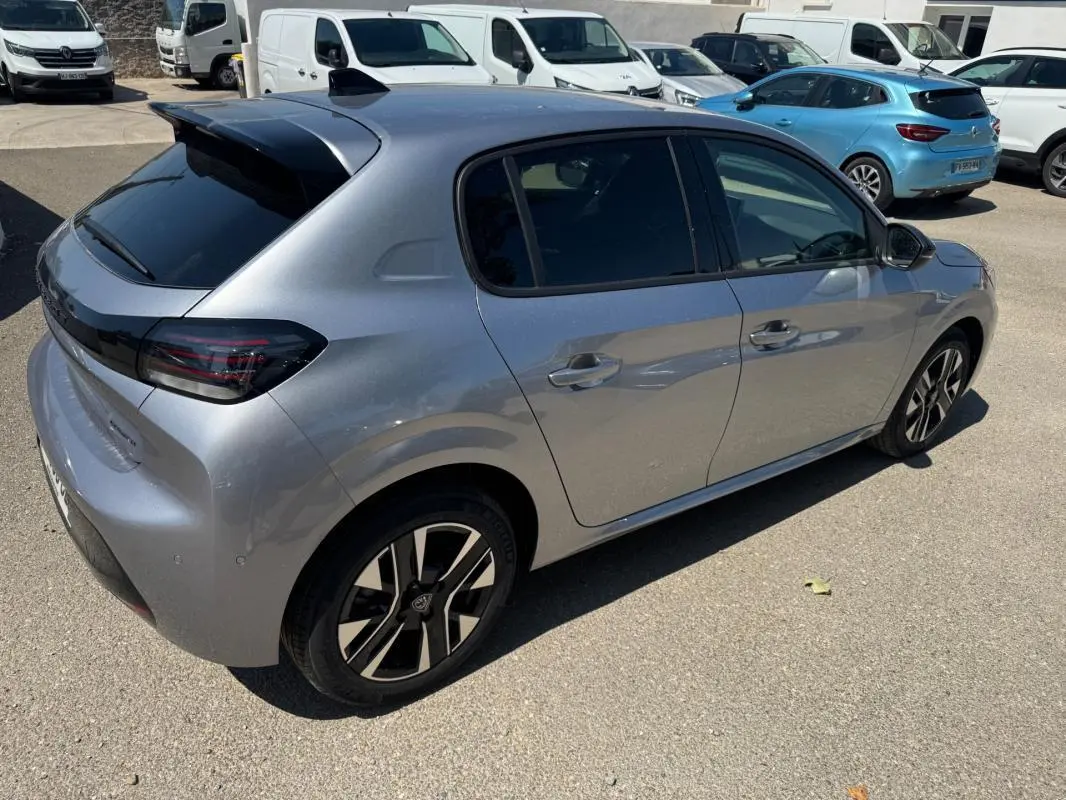 Vue 3/4 arrière droite d'une Peugeot 208 Hybrid 110 gris métallisé avec jantes alliage 16 pouces et antenne requin.
