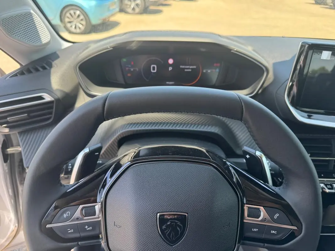 Vue rapprochée du volant cuir noir et du cockpit numérique de la Peugeot 208 Hybrid 110 e-DCS6 Allure 2025.