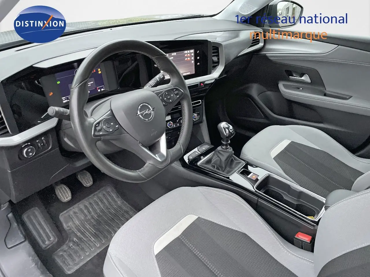 Intérieur de l'Opel Mokka 1.5 CDTI 2021 vu côté conducteur, tableau de bord moderne et sièges gris clair et noir.