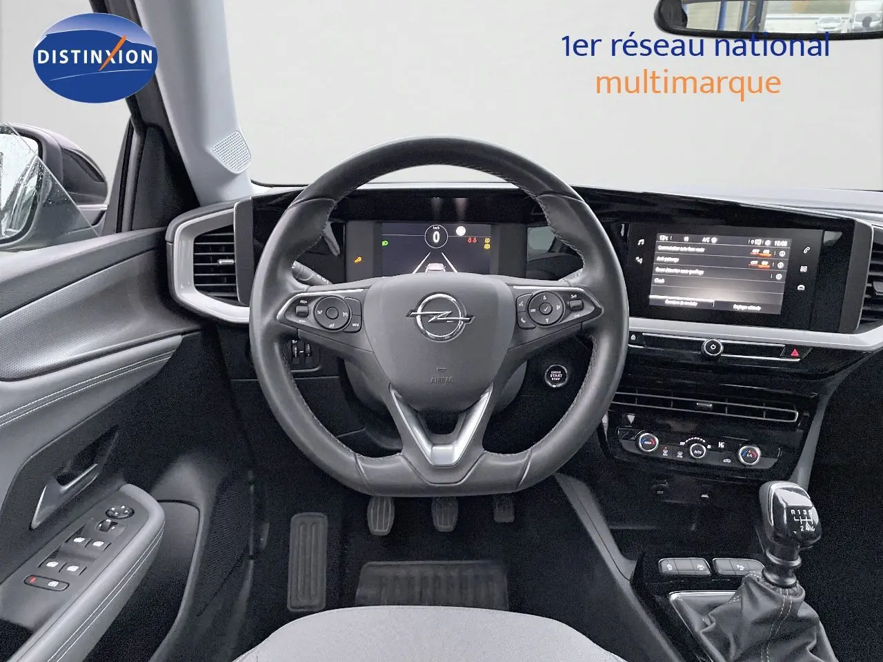 Intérieur de l'Opel Mokka 2021 diesel, vue frontale sur le volant cuir, tableau de bord numérique et levier de vitesse manuel.
