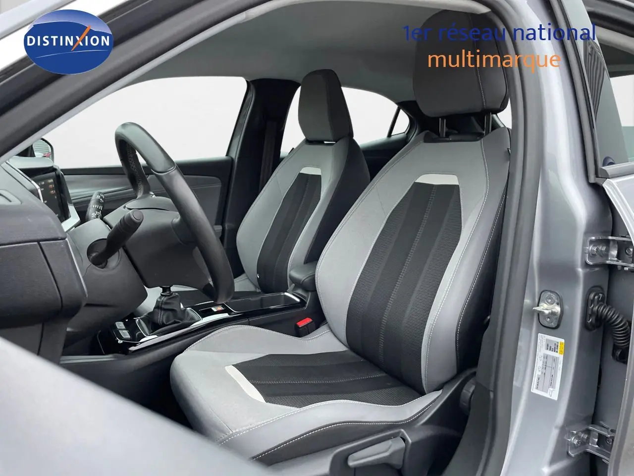 Intérieur de l'Opel Mokka gris Artens métal 2021, vue côté conducteur sur les sièges bicolores et la boîte manuelle.