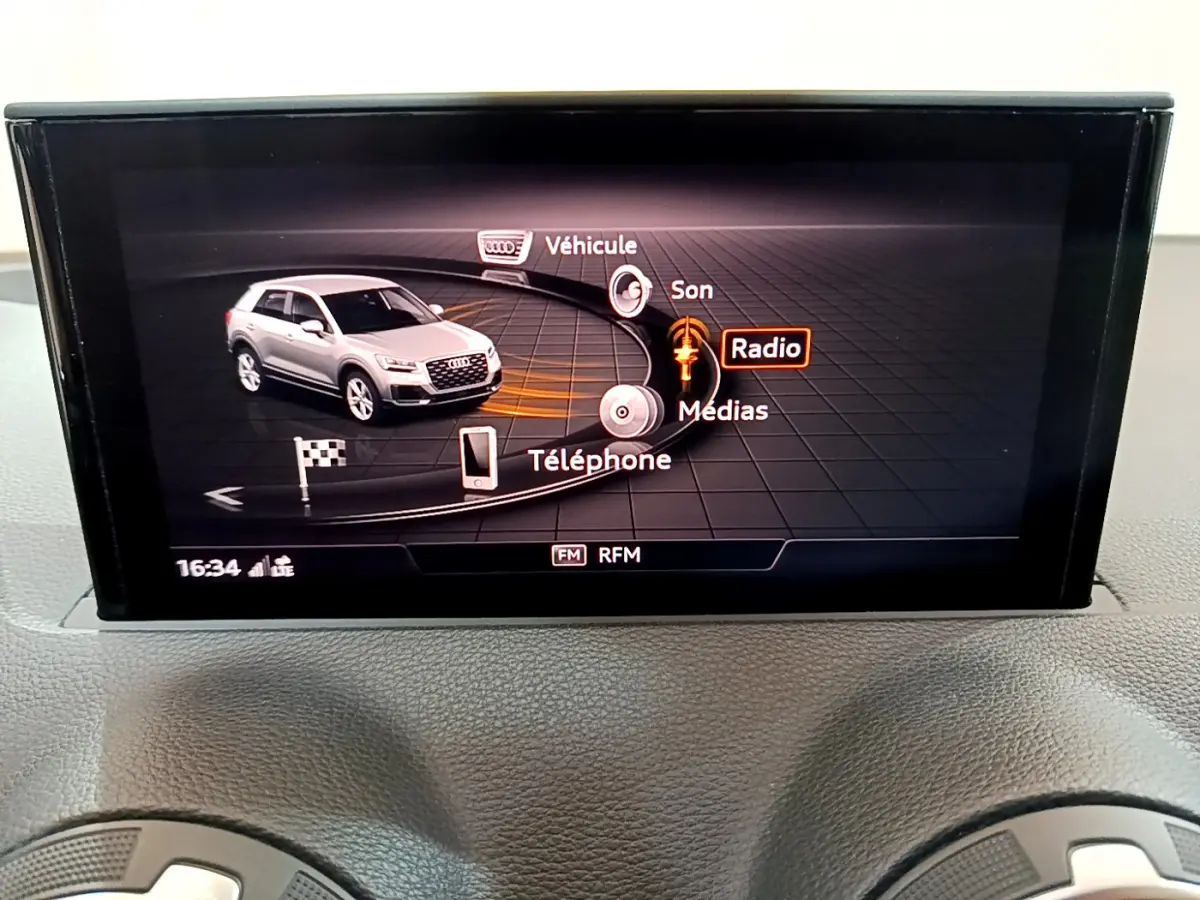 Écran central de l’Audi Q2 gris clair 2020 affichant le menu multimédia avec options Radio, Téléphone et Véhicule.