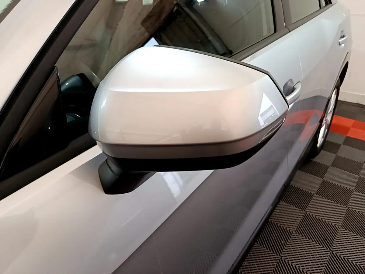 Gros plan sur le rétroviseur côté gauche gris clair de l'Audi Q2 35 TDI 150 Design, vue partielle de la portière.
