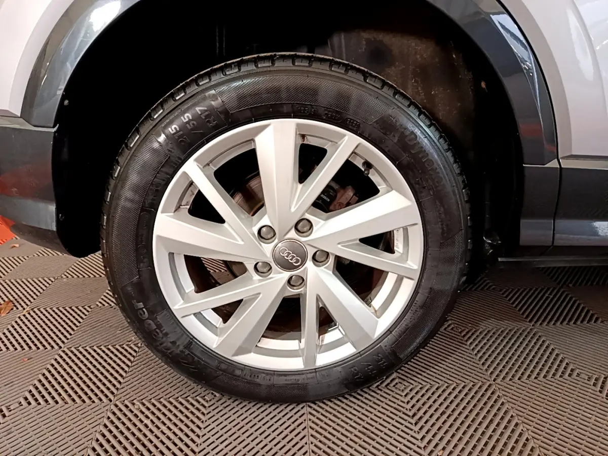 Gros plan sur la roue avant droite gris clair de l'Audi Q2 35 TDI 150 Design avec jante alliage à 5 doubles branches.