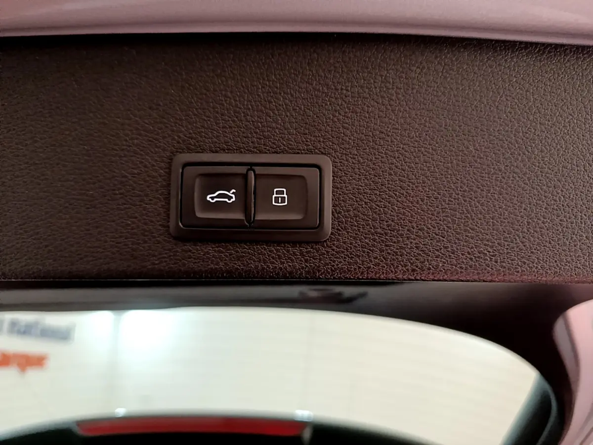 Gros plan sur les boutons d'ouverture et de verrouillage du coffre à l'intérieur d'un Audi Q2 gris clair 2020.