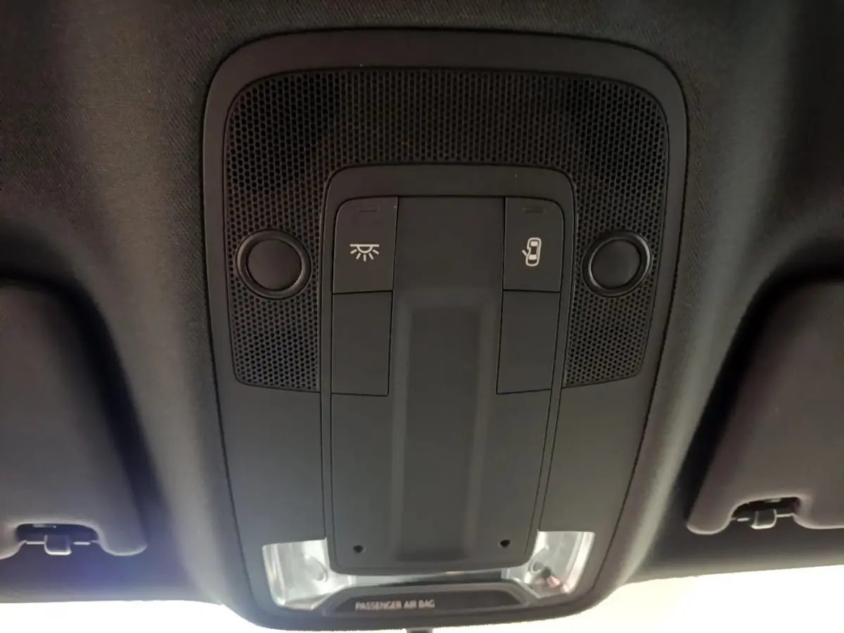 Vue en gros plan du plafonnier noir avec commandes d’éclairage et ouverture de toit de l’Audi Q2 gris clair 2020.
