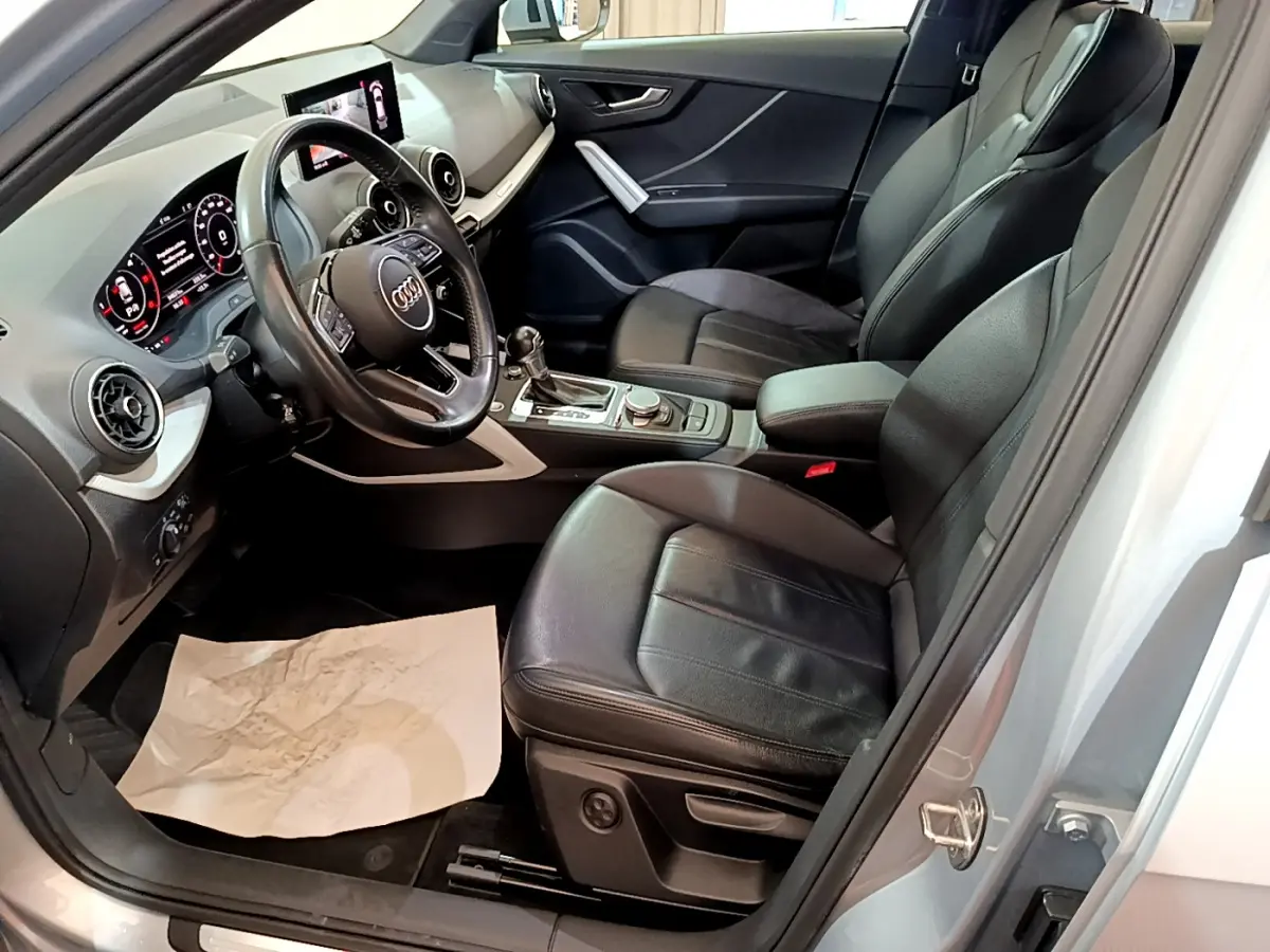 Intérieur noir de l'Audi Q2 35 TDI 150 Design 2020 vu côté conducteur, avec tableau de bord digital et volant cuir.