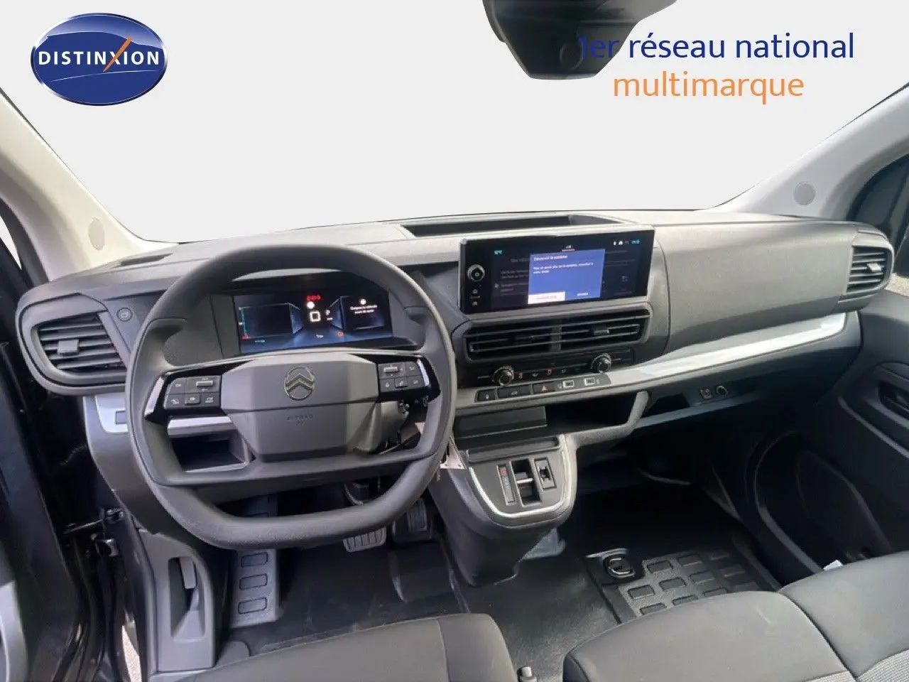 Vue intérieure du poste de conduite du Citroën Jumpy gris titane, avec tableau de bord numérique et écran central tactile.