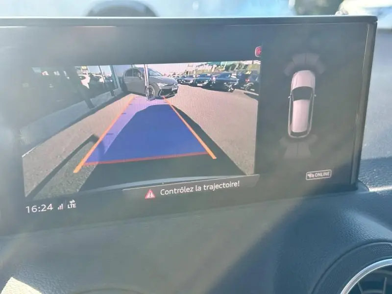 Écran de caméra de recul montrant un Audi Q2 blanc de dos avec porte arrière ouverte, vue depuis l'arrière droit.