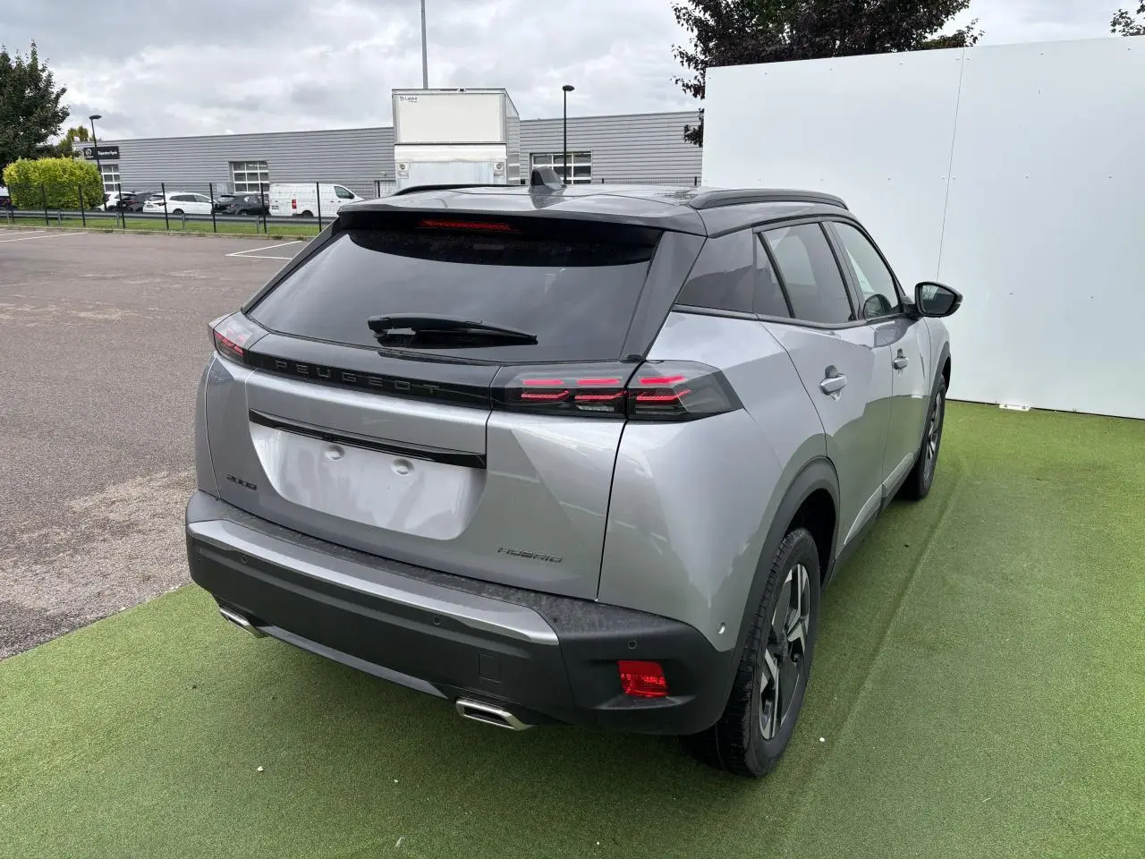 Vue 3/4 arrière droite du Peugeot 2008 gris Artense avec toit noir et feux arrière LED à 3 griffes.