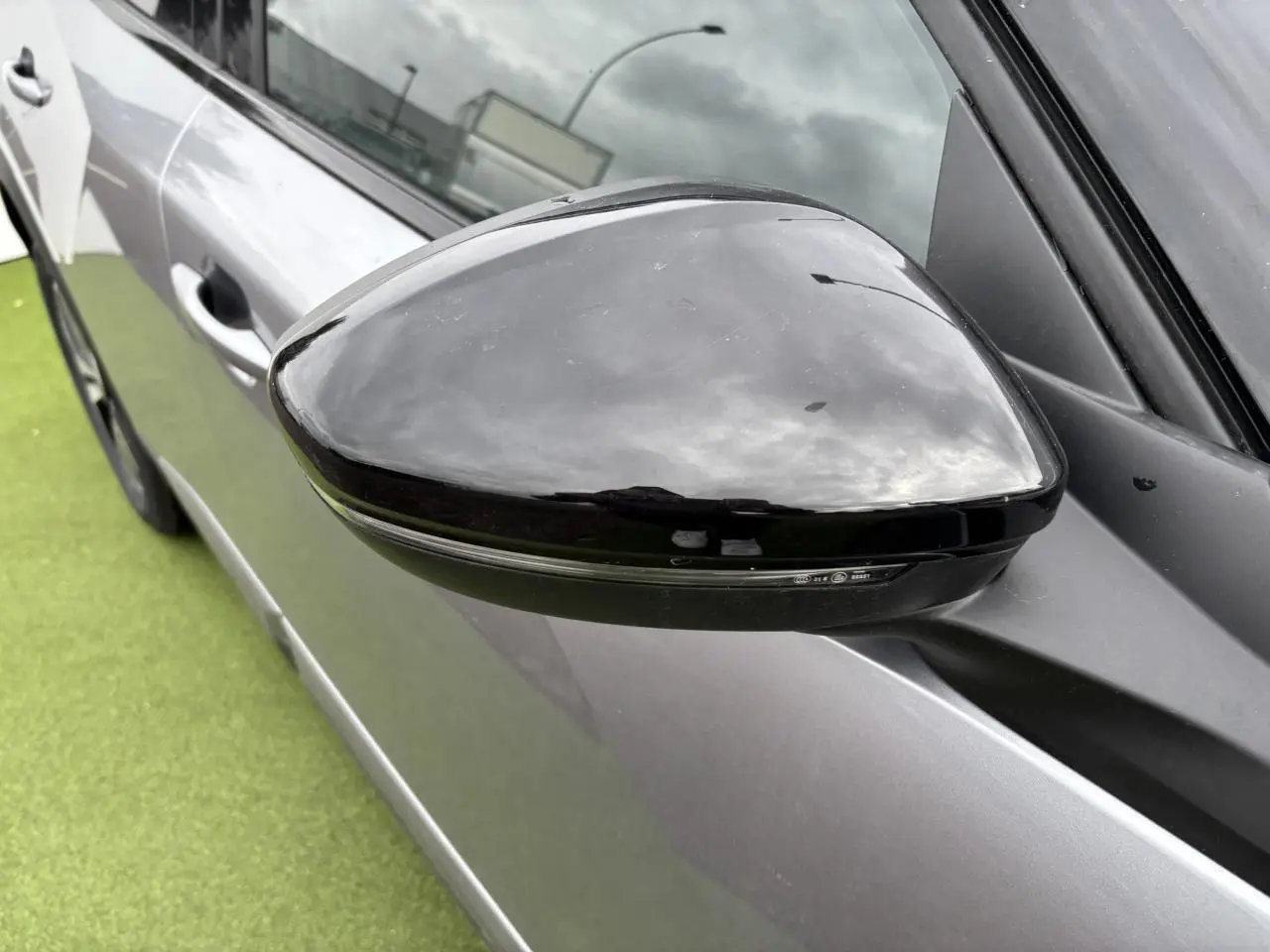 Rétroviseur noir brillant côté gauche du Peugeot 2008 gris Artense avec toit noir, vue rapprochée en extérieur.