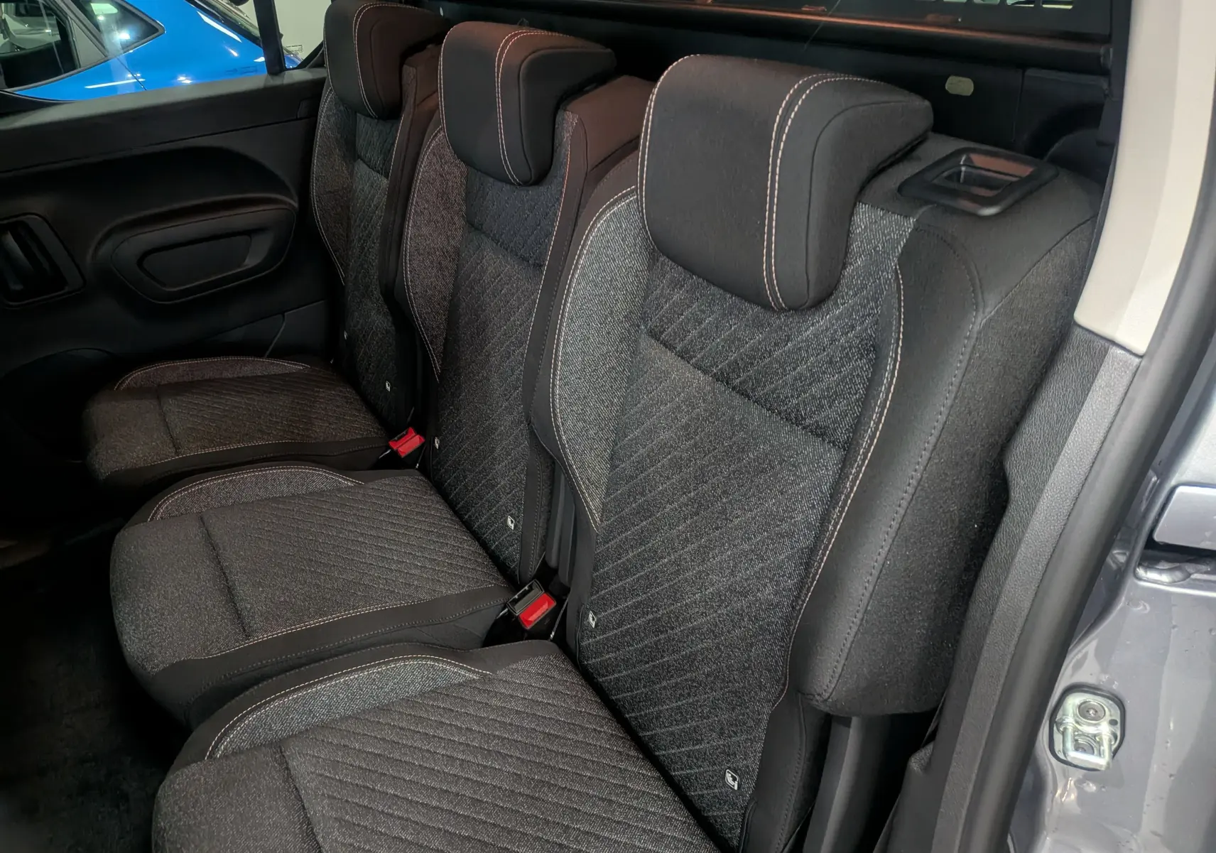 Vue intérieure côté droit des sièges arrière en tissu gris du Peugeot Rifter 2025 gris acier, version 5 places.