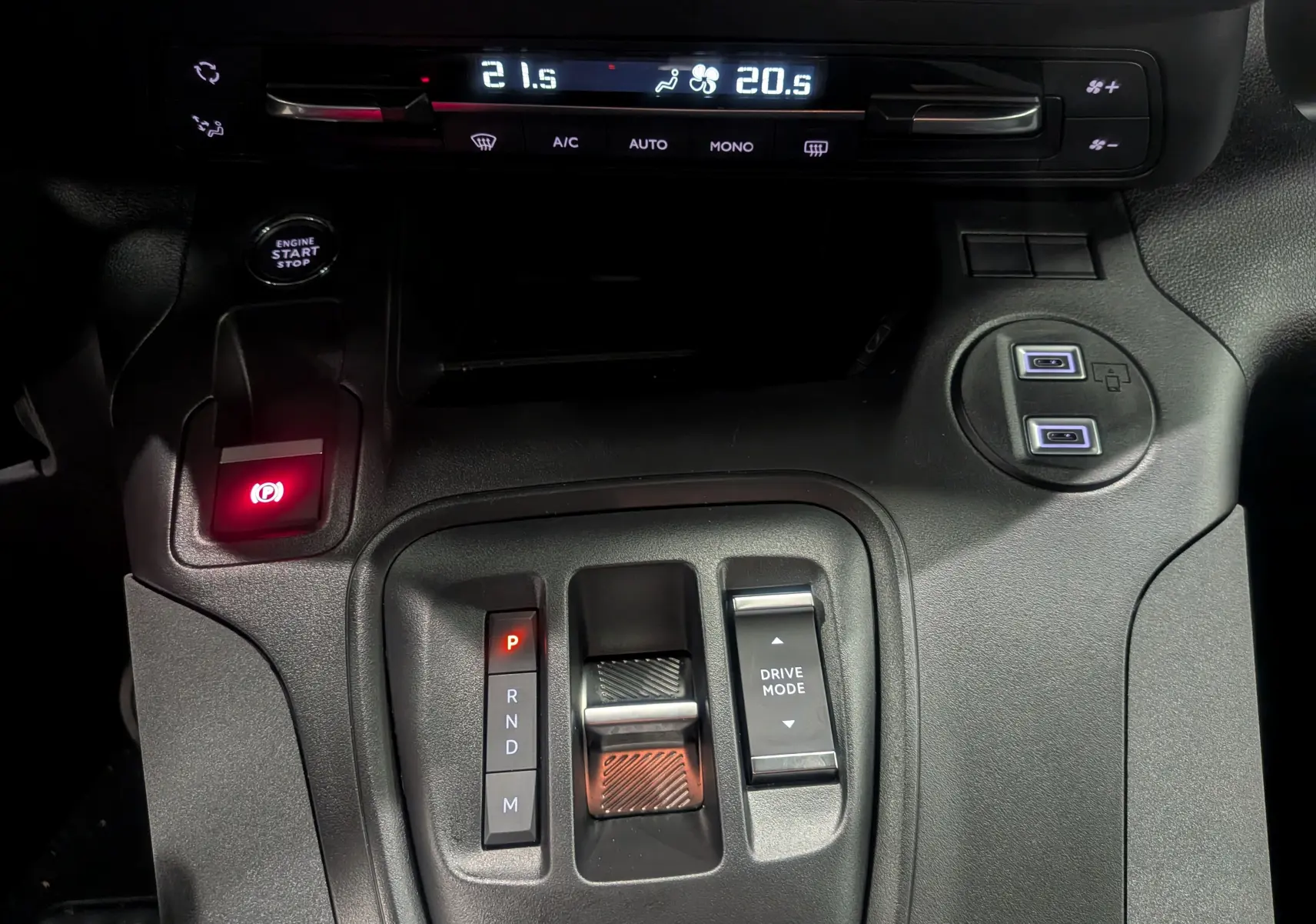Vue rapprochée de la console centrale du Peugeot Rifter gris acier 2025, avec levier de vitesses automatique et commandes climatisation.