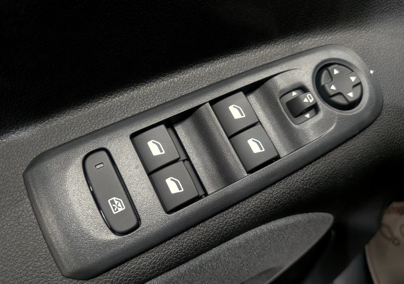 Gros plan sur les commandes de lève-vitres et réglage des rétroviseurs côté gauche du Peugeot Rifter gris acier 2025.