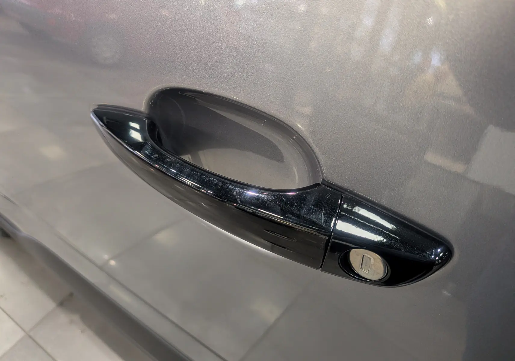 Poignée de porte noire sur la portière gris acier côté gauche du Peugeot Rifter 2025 version Allure.