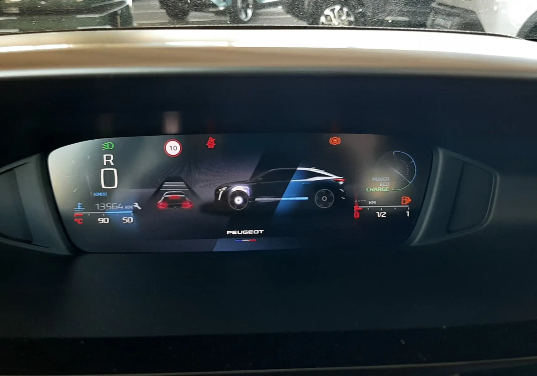 Affichage numérique du tableau de bord du Peugeot 408 Hybrid 145ch en mode stationnement, avec indicateurs de charge et vitesse.