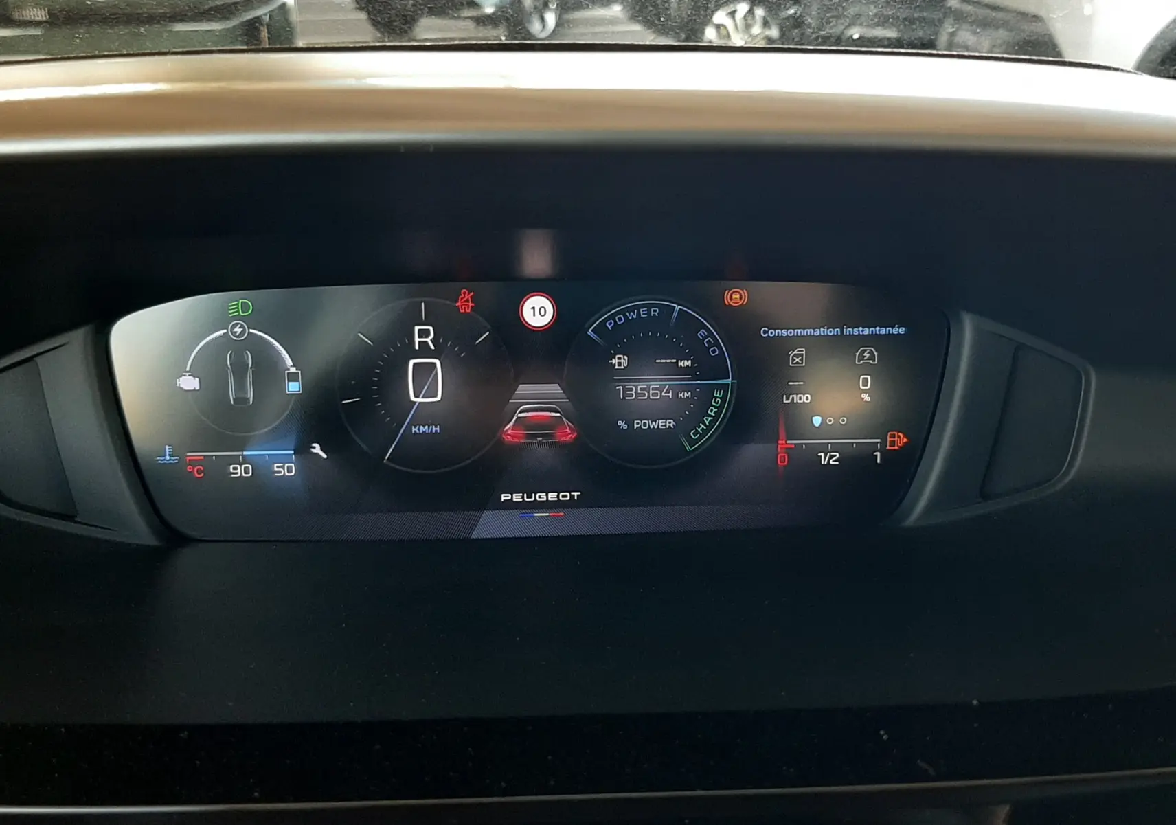Vue rapprochée du tableau de bord numérique du Peugeot 408 Hybrid 145ch, affichant les informations de conduite et consommation.