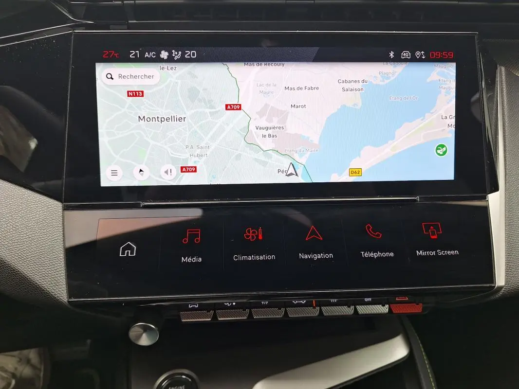 Vue rapprochée de l'écran tactile central et de la console multimédia du Peugeot 308 Hybrid 145 e-DCS6 GT gris 2025.