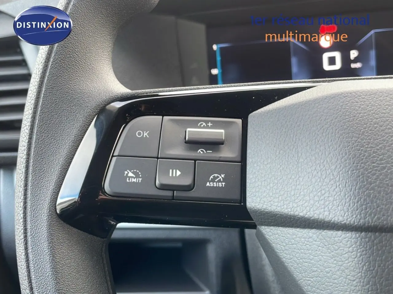 Gros plan sur les commandes noires du volant du Citroën Jumpy gris titane, avec affichage numérique en arrière-plan.